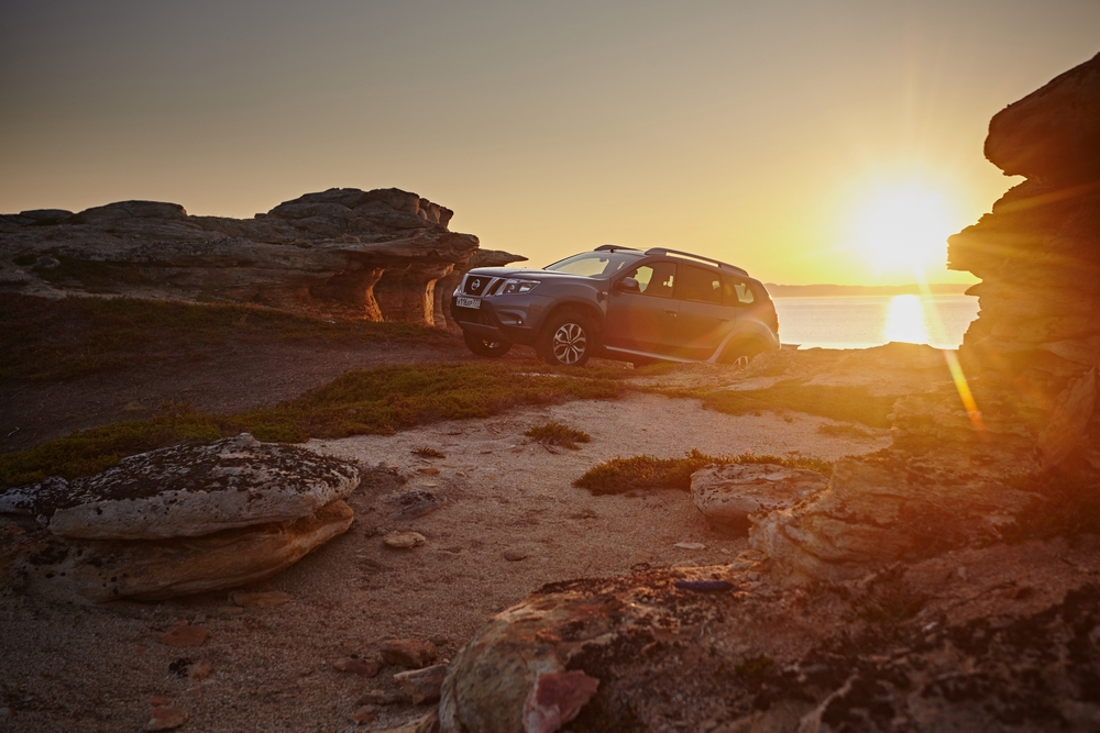 Nissan SUV Colorado mountain road at sunset, high-altitude driving conditions Colorado Springs, Nissan Pathfinder or Rogue scenic view, Woodmen Nissan Colorado Springs dealership, summer driving protection for Nissan engine oil, mountain road performance Nissan service near me